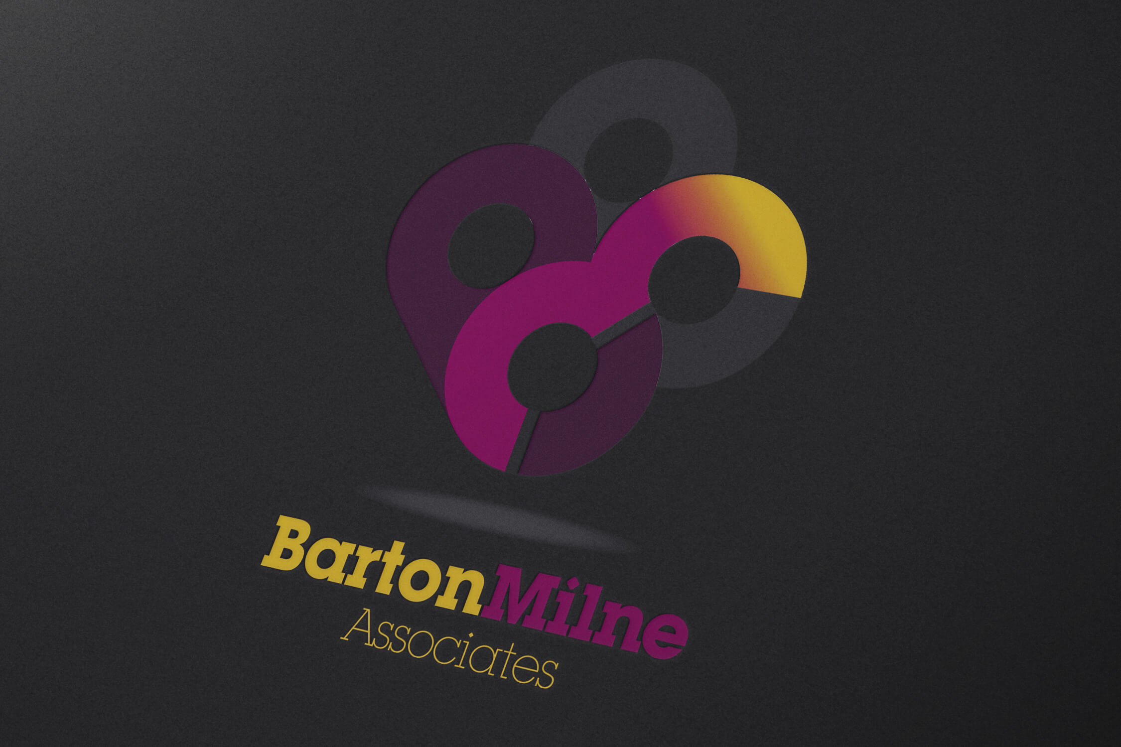 The Barton Milne Associates logo on dark paper background