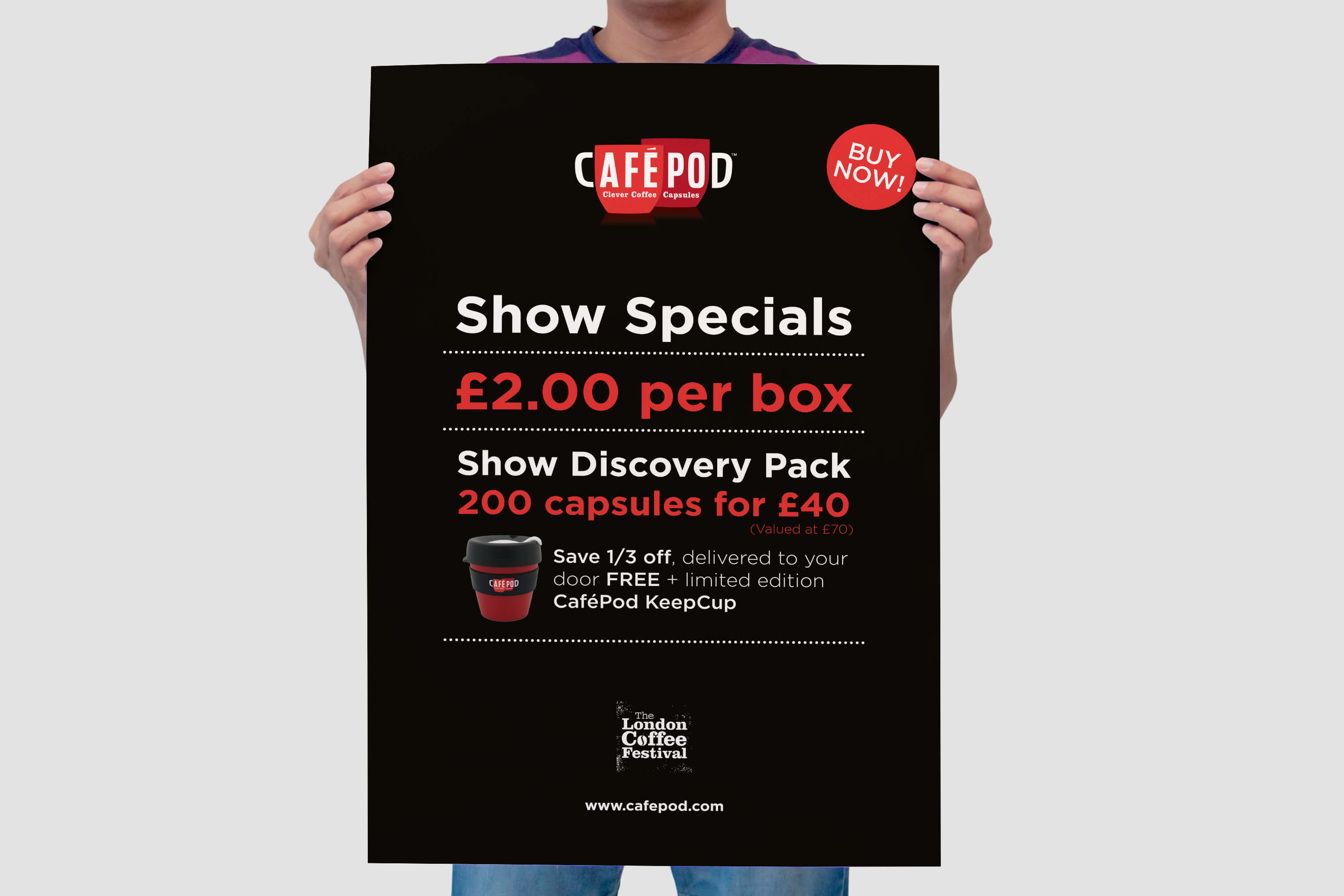 Person holding a printed CaféPod table talker poster for a trade show