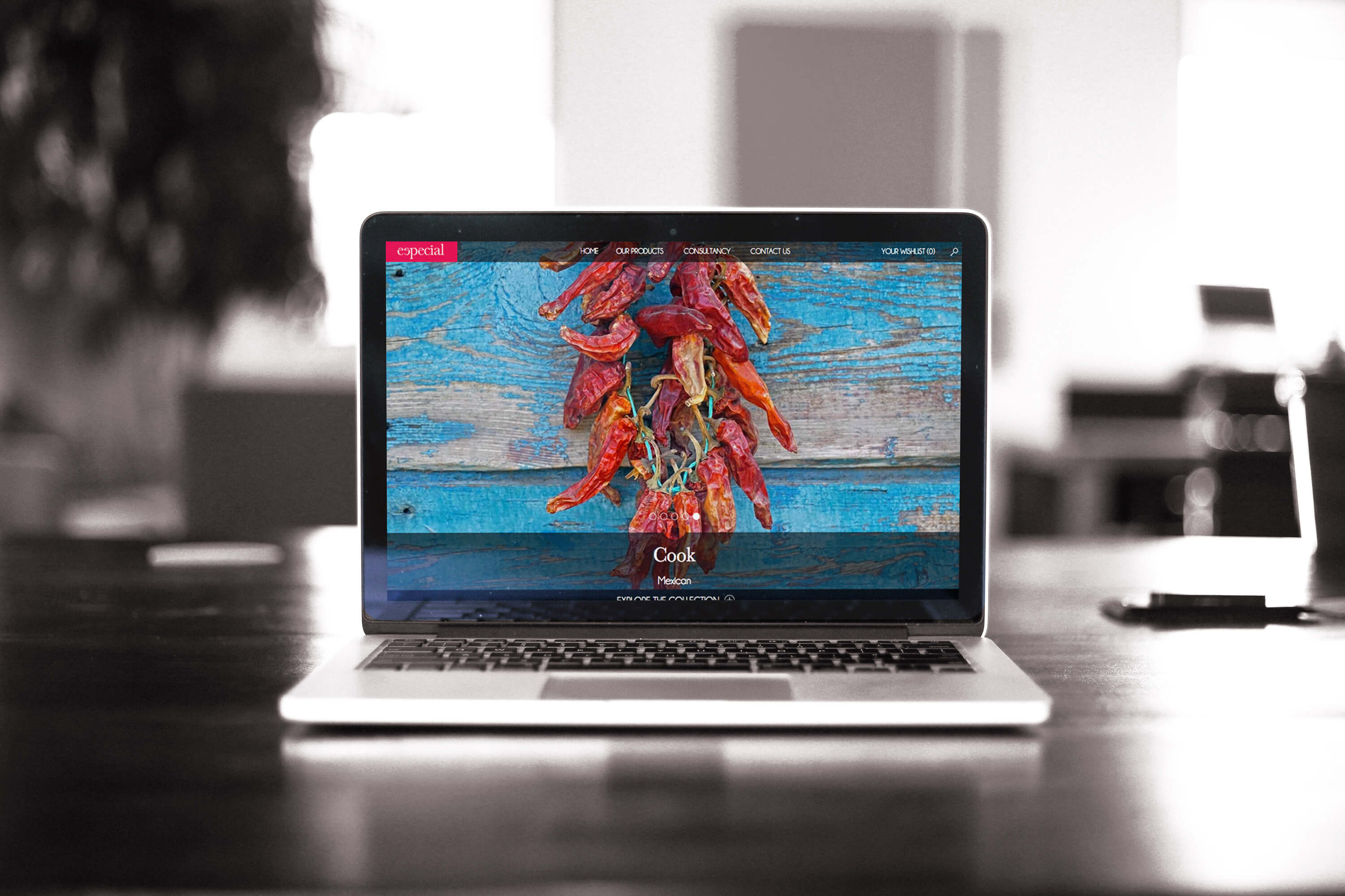 A laptop on a desk showing the Especial website home page design