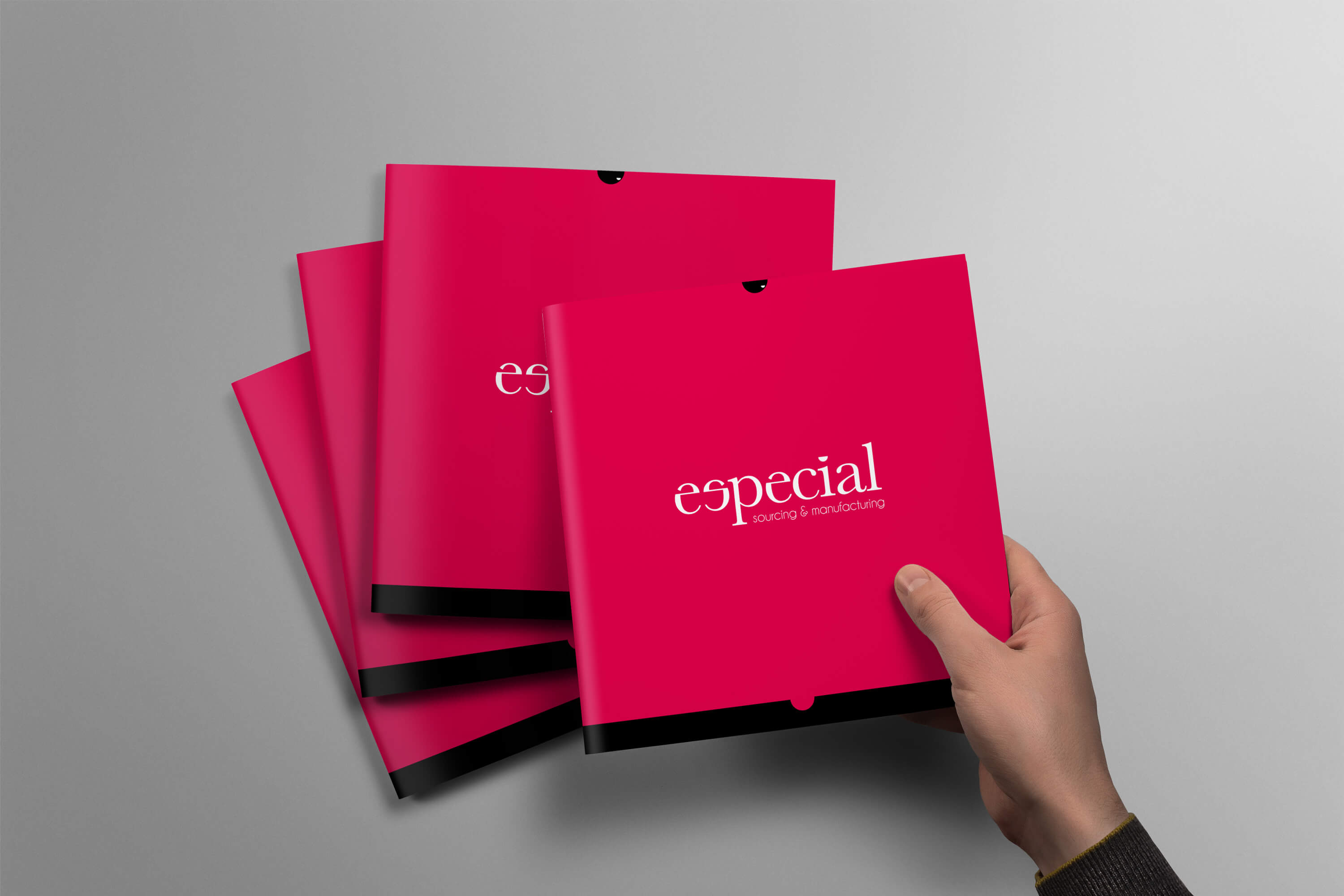 Person taking a copy of the Especial Sourcing and Manufacturing brochure from the top of a pile of brochures