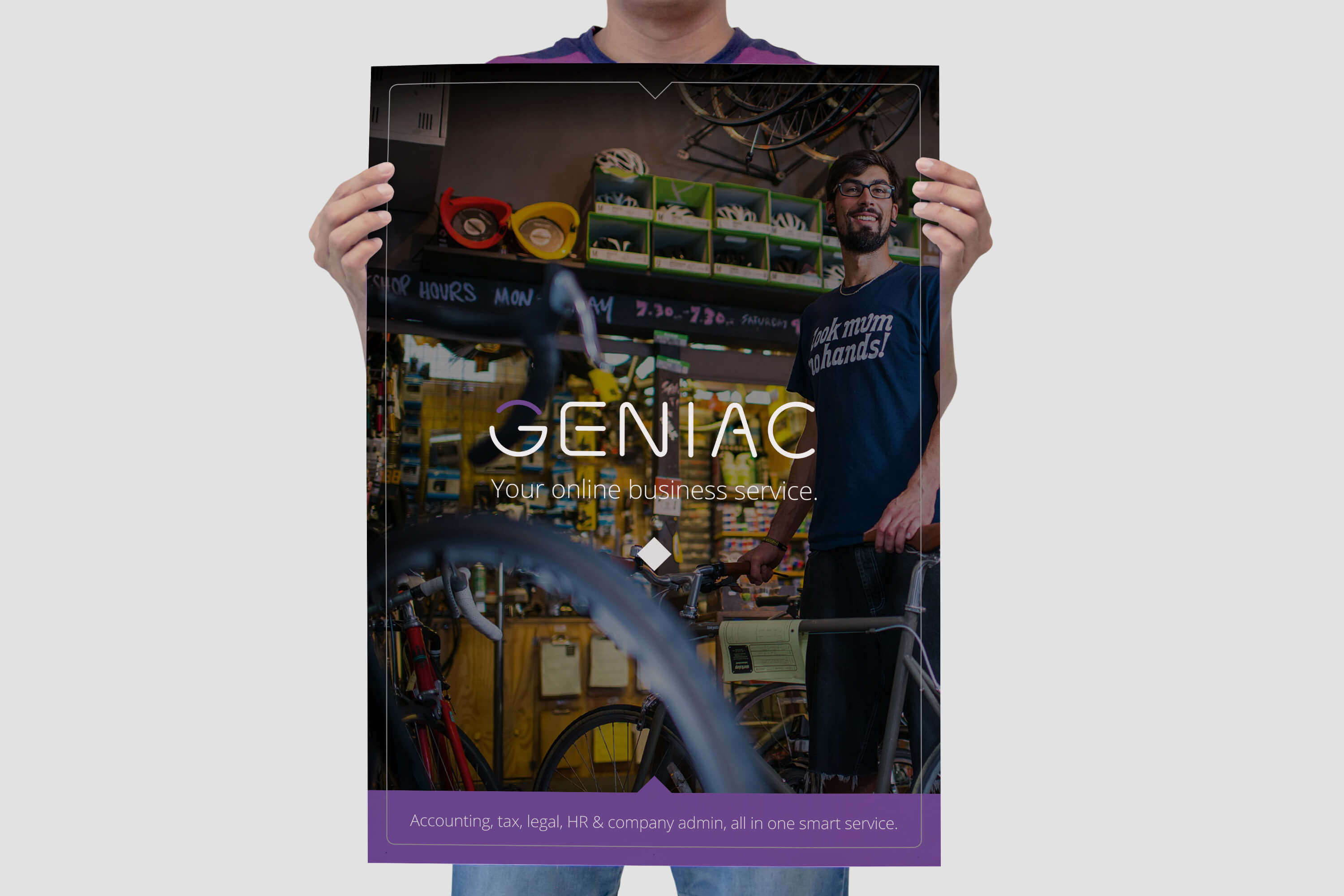 A person holding a poster sized copy of the Geniac brochure cover