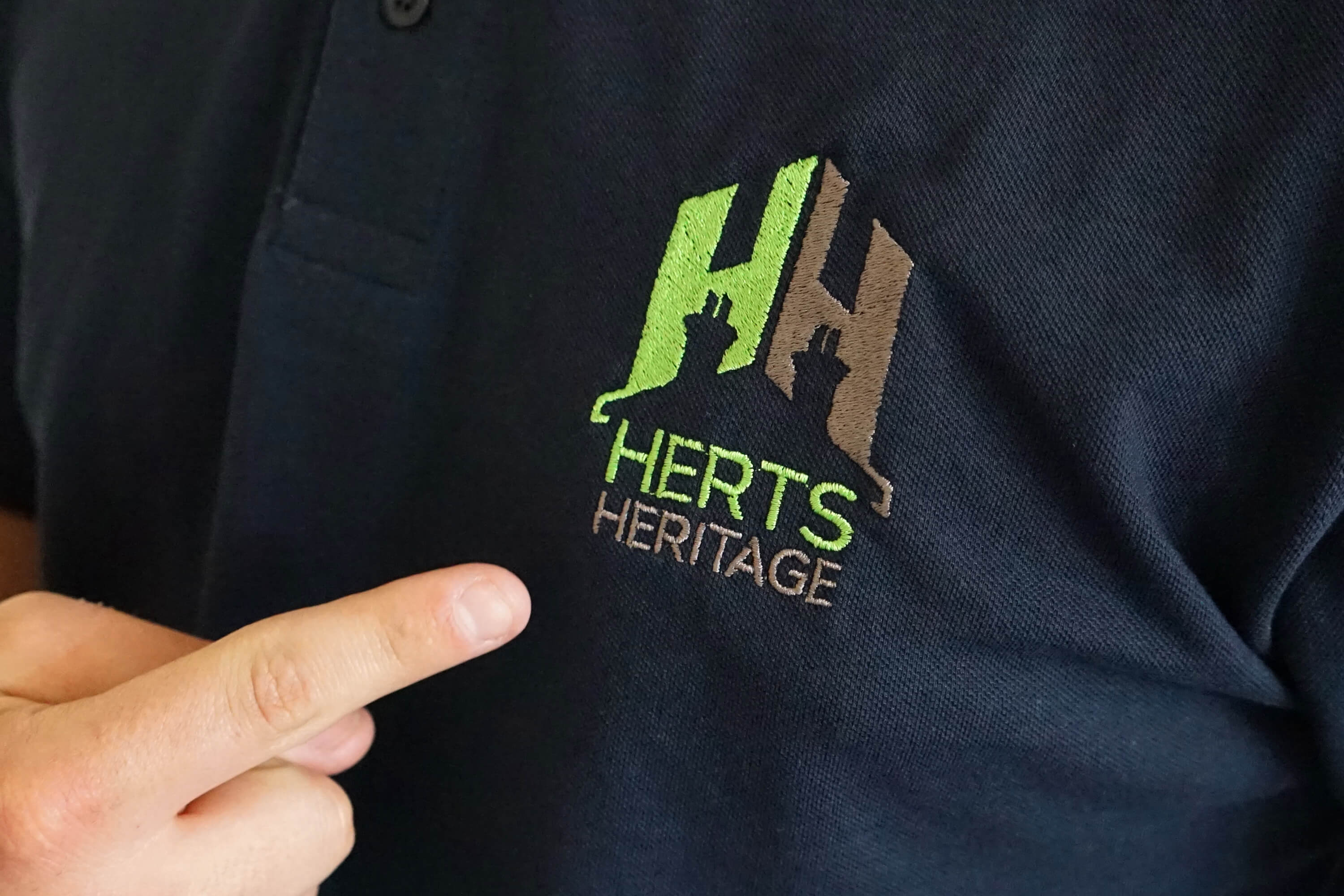 Close up of Herts Heritage shirt and embroidered logo as part of rebrand