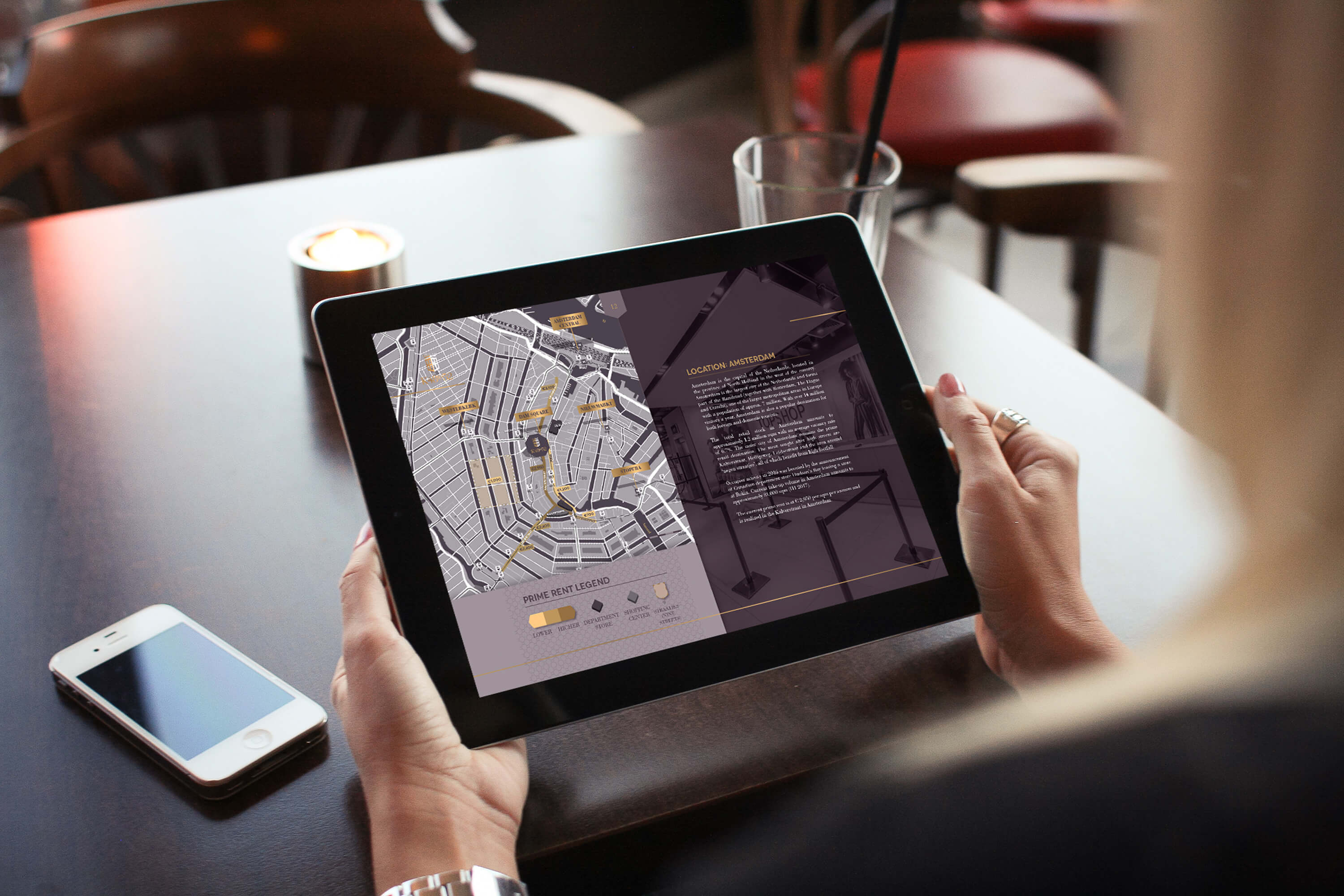 A woman holding a tablet showing the bespoke map and internal page within the JLL K48to52 investment memorandum design