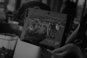 Black and white image of a woman holding a tablet showing the Dawsons Square branding