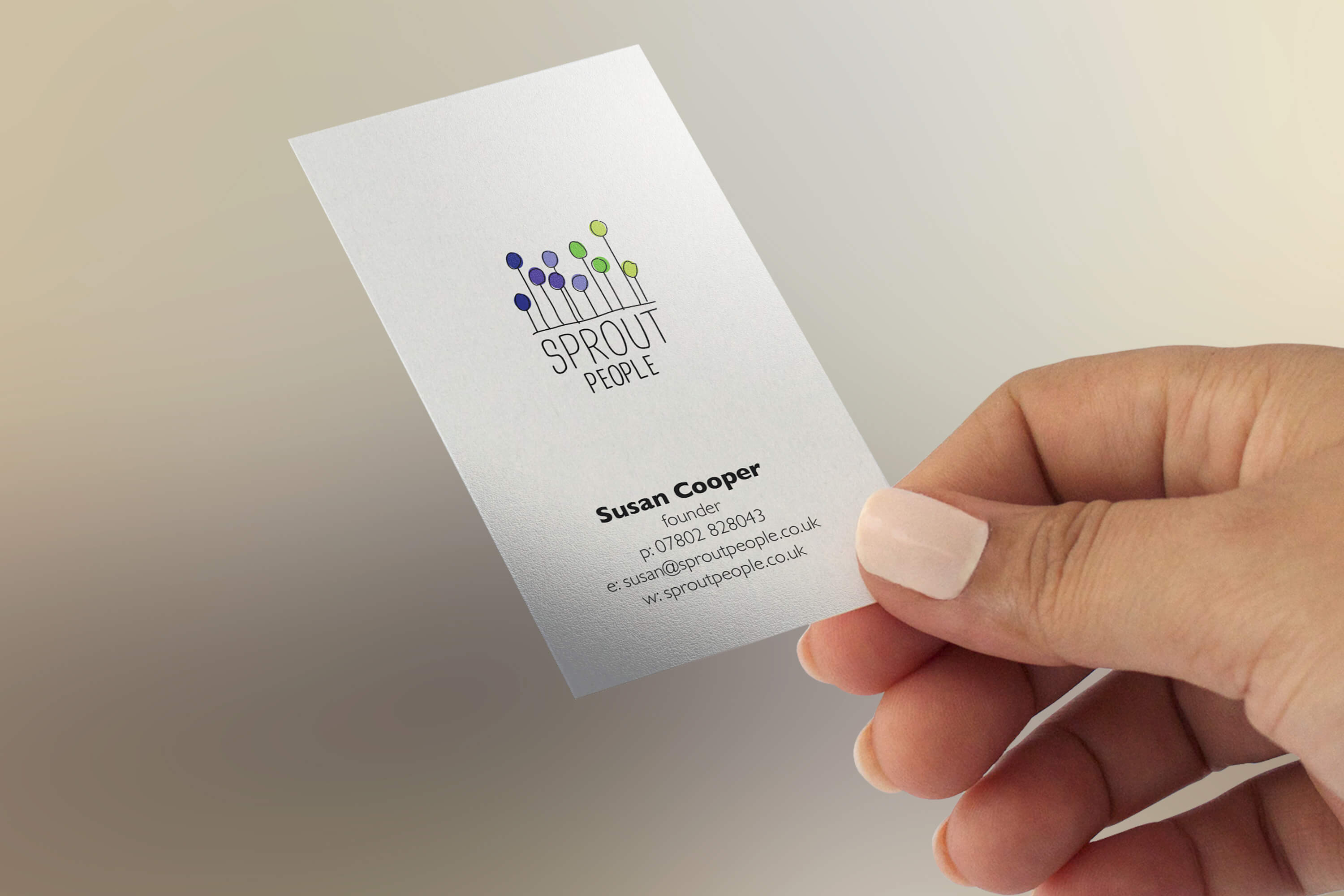 A woman's hand holding a copy of the Sprout People business card design