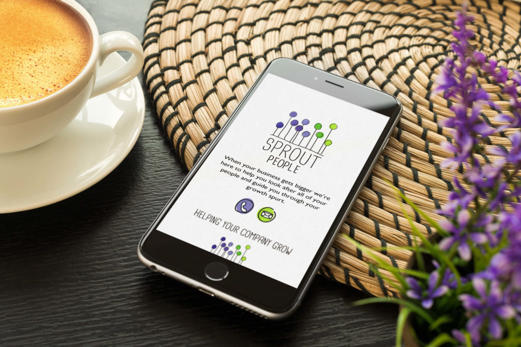 An iPhone sitting next to a coffee showing the Sprout People website design