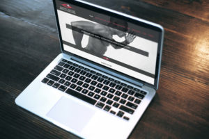 A laptop on a desk showing a section of the Zamri Ismail website home page design